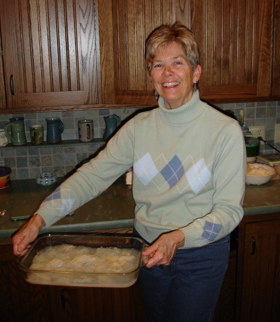 Woman holding glass 9x13-inch pan filled with lutefisk